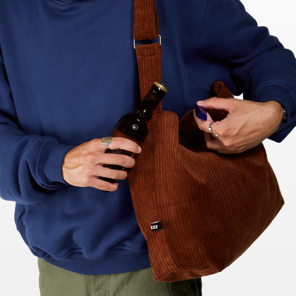 Close-up of the bottle opener on the BIRGER rust brown sling bag