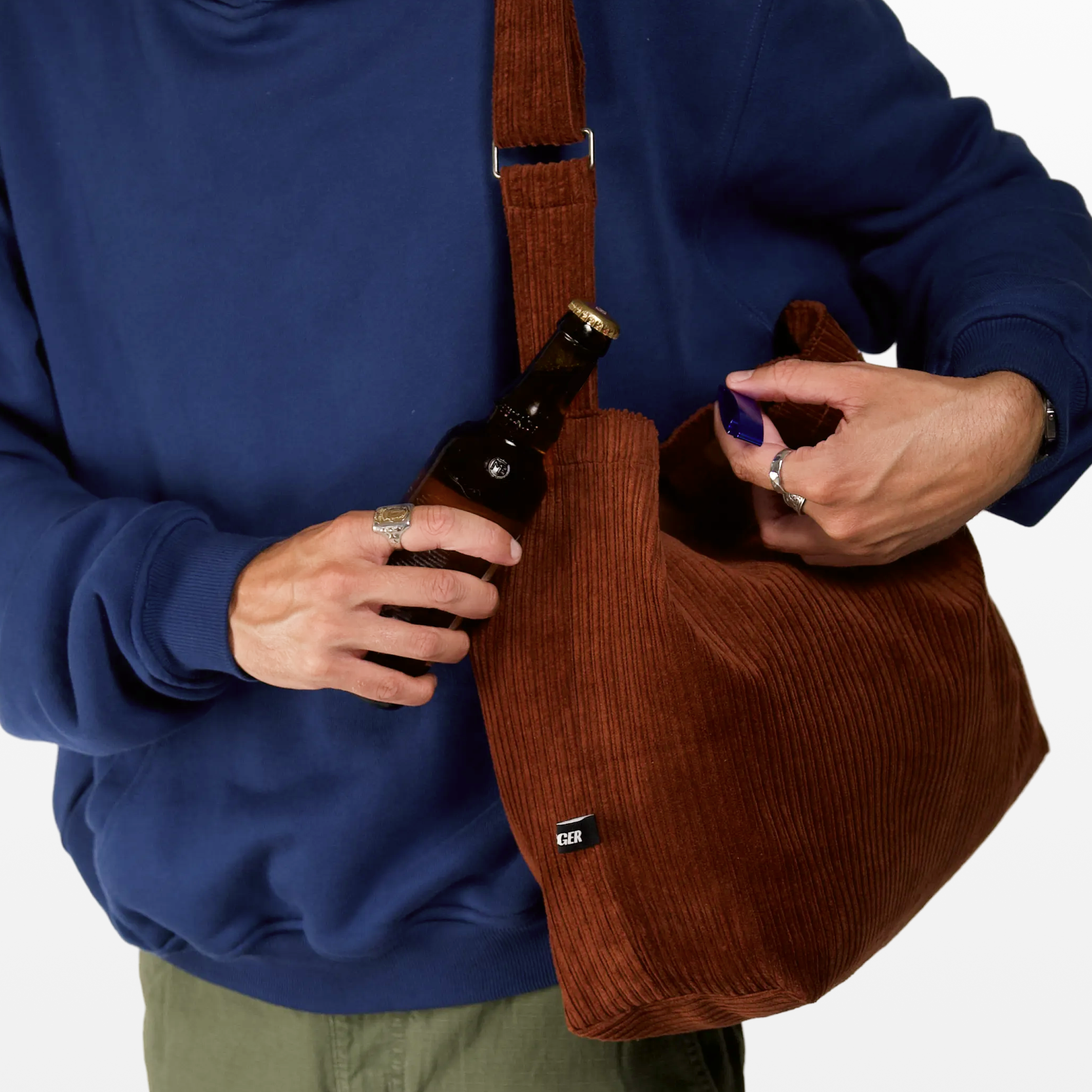 Close-up of the bottle opener on the BIRGER rust brown sling bag
